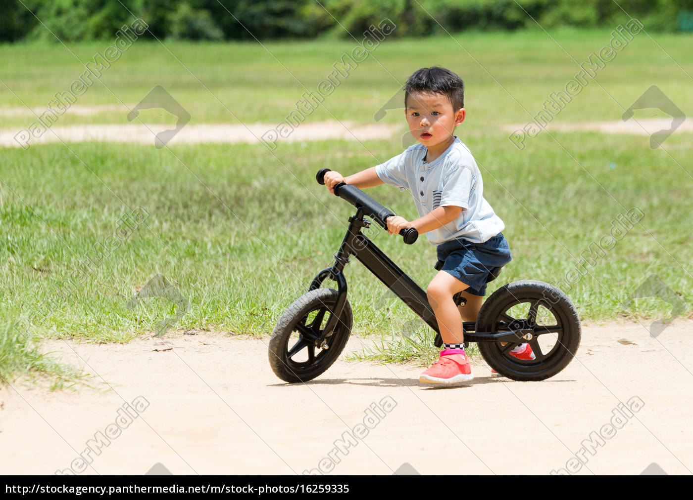 Baby boy riding with balance bicycle 